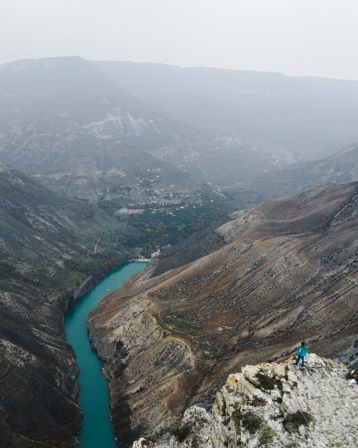 contact-img A breathtaking aerial view of a tranquil river winding through a rugged mountain valley.