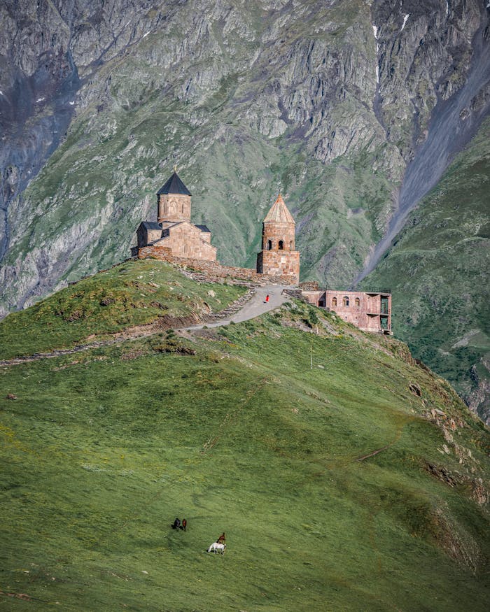 View of Gergeti Trinity Church against the stunning Caucasus Mountains landscape in Georgia.