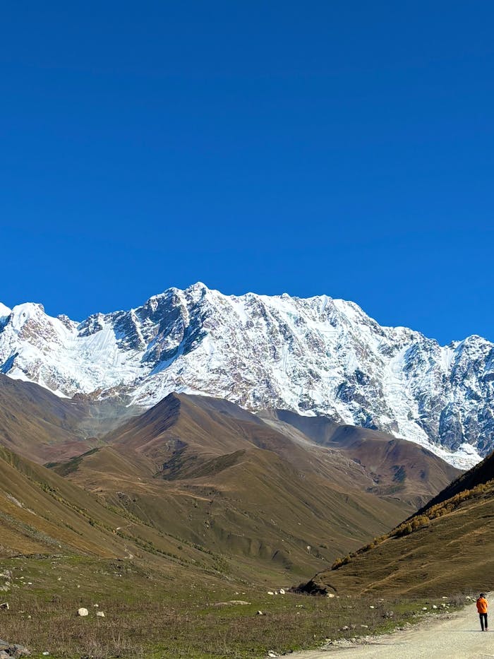 our-experience Stunning view of the snow-capped mountains in Georgia, against a vivid blue sky.